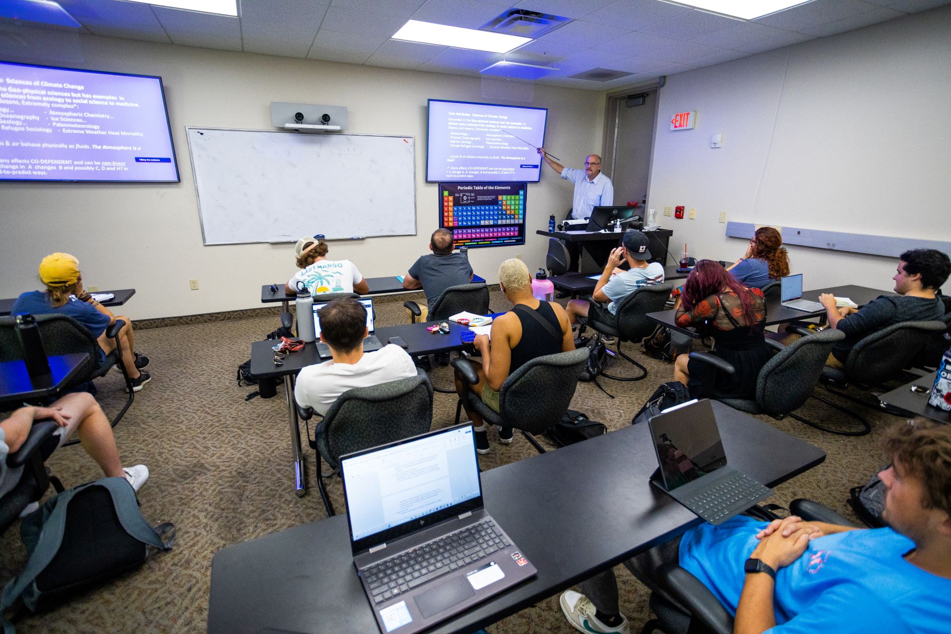 Classroom with students attentively watching a professor giving a presentation